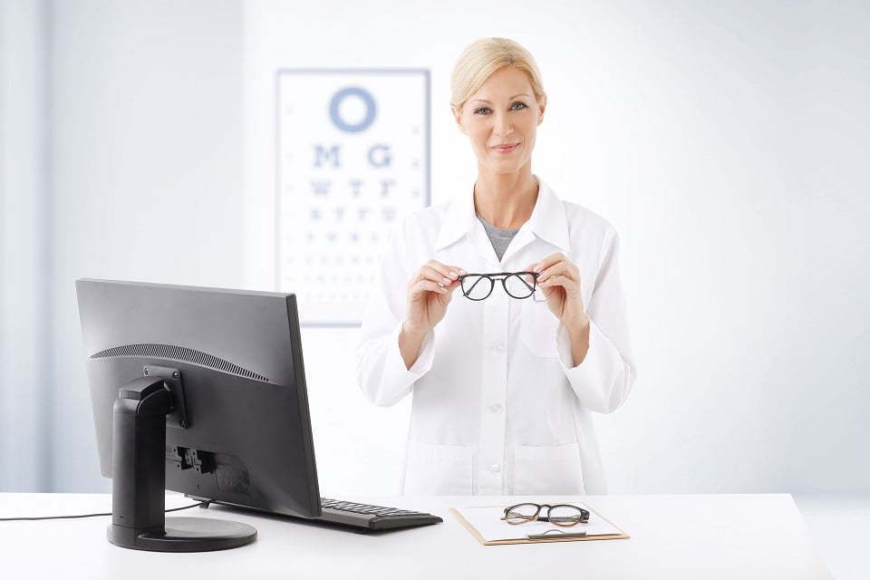Eye doctor holding up pair of glasses